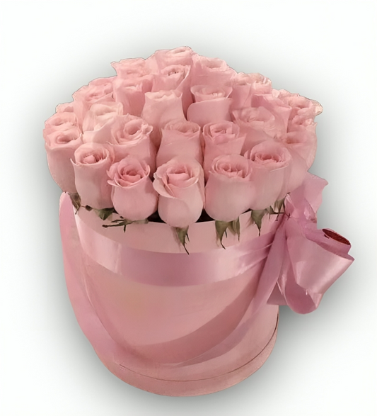 Elegant round pink box filled with soft pink roses and tied with a satin ribbon bow, photographed on a clean white background with the watermark "flowershopping.gr" in dark grey letters at the bottom 