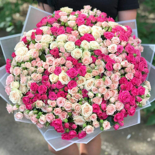 A bouquet of pink and white spray roses held by a person for Athens flower delivery in all areas
